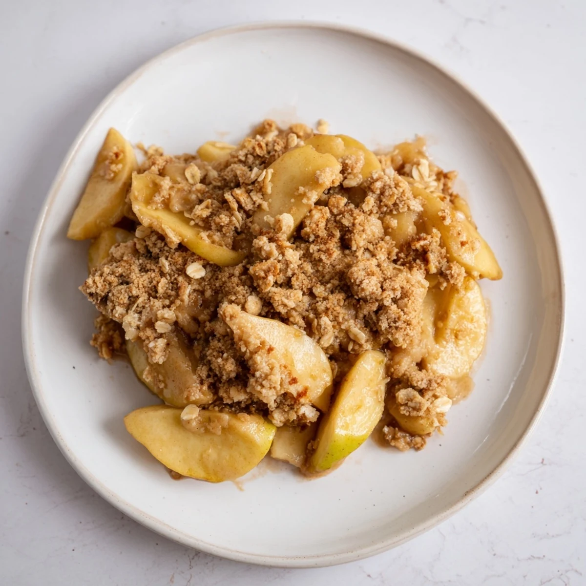 Warm Rustic Apple and Cinnamon Crumble bubbling with juicy apple filling and golden crumb topping.