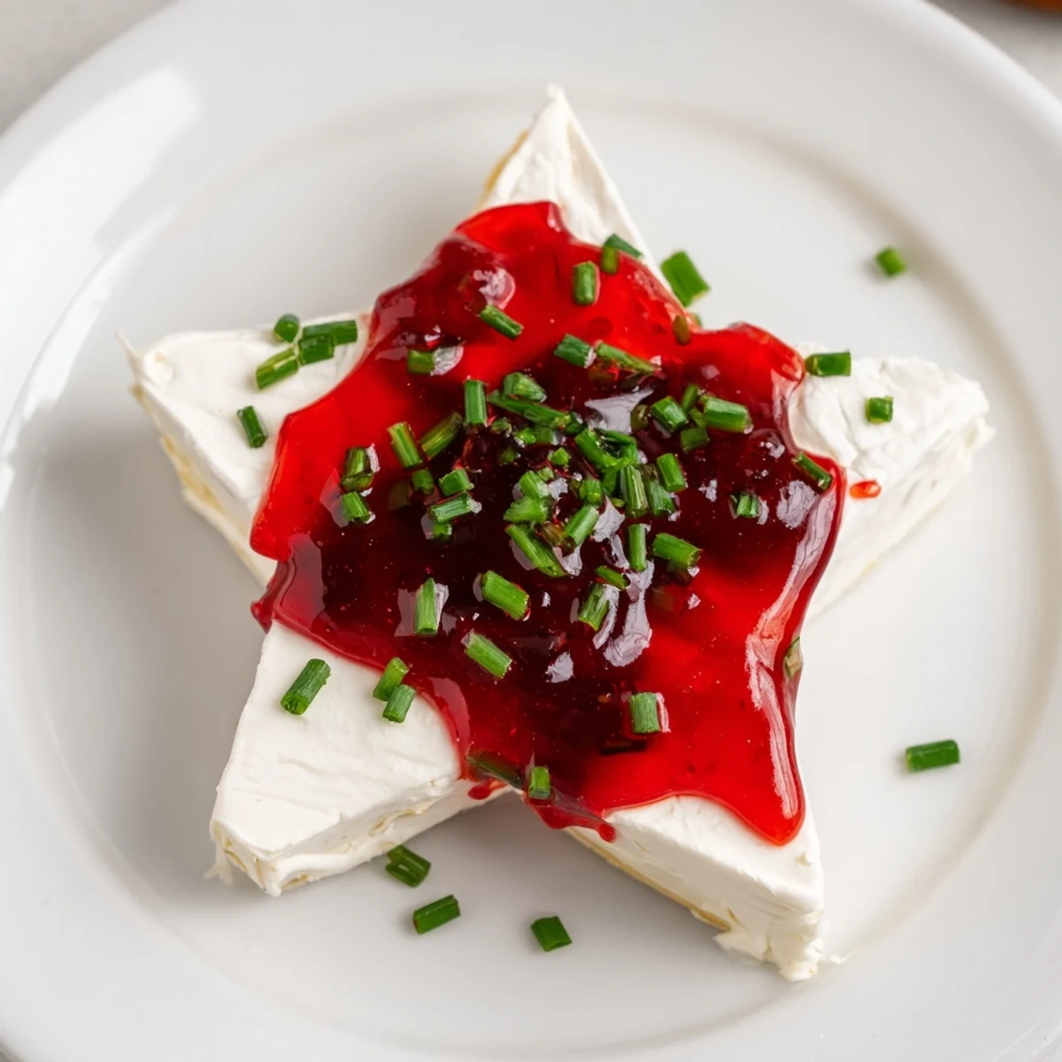 Cream cheese and pepper jelly star appetizer, a beautiful, festive party dish with vibrant red jelly.