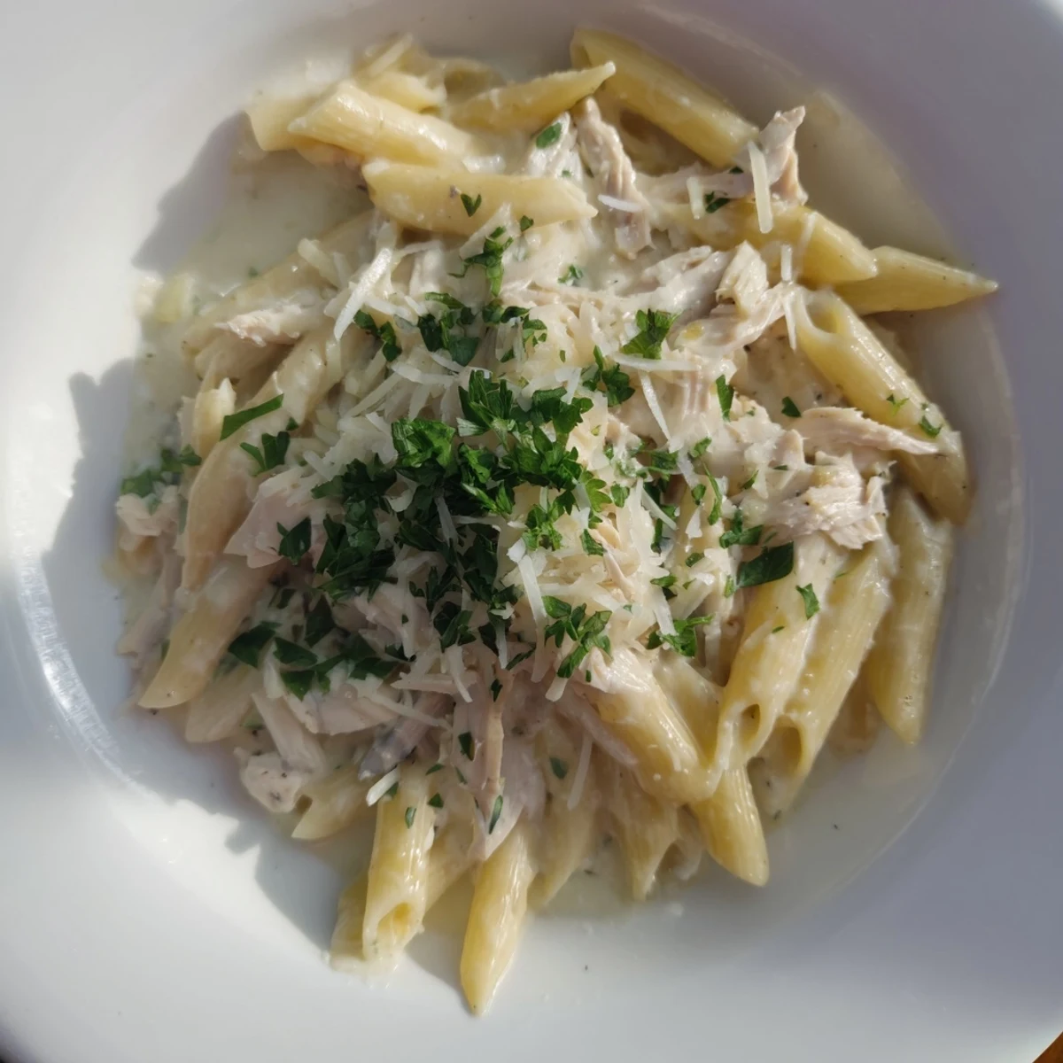 A close-up view of Tinis Creamy Chicken Pasta, ready to serve for a comforting dinner.