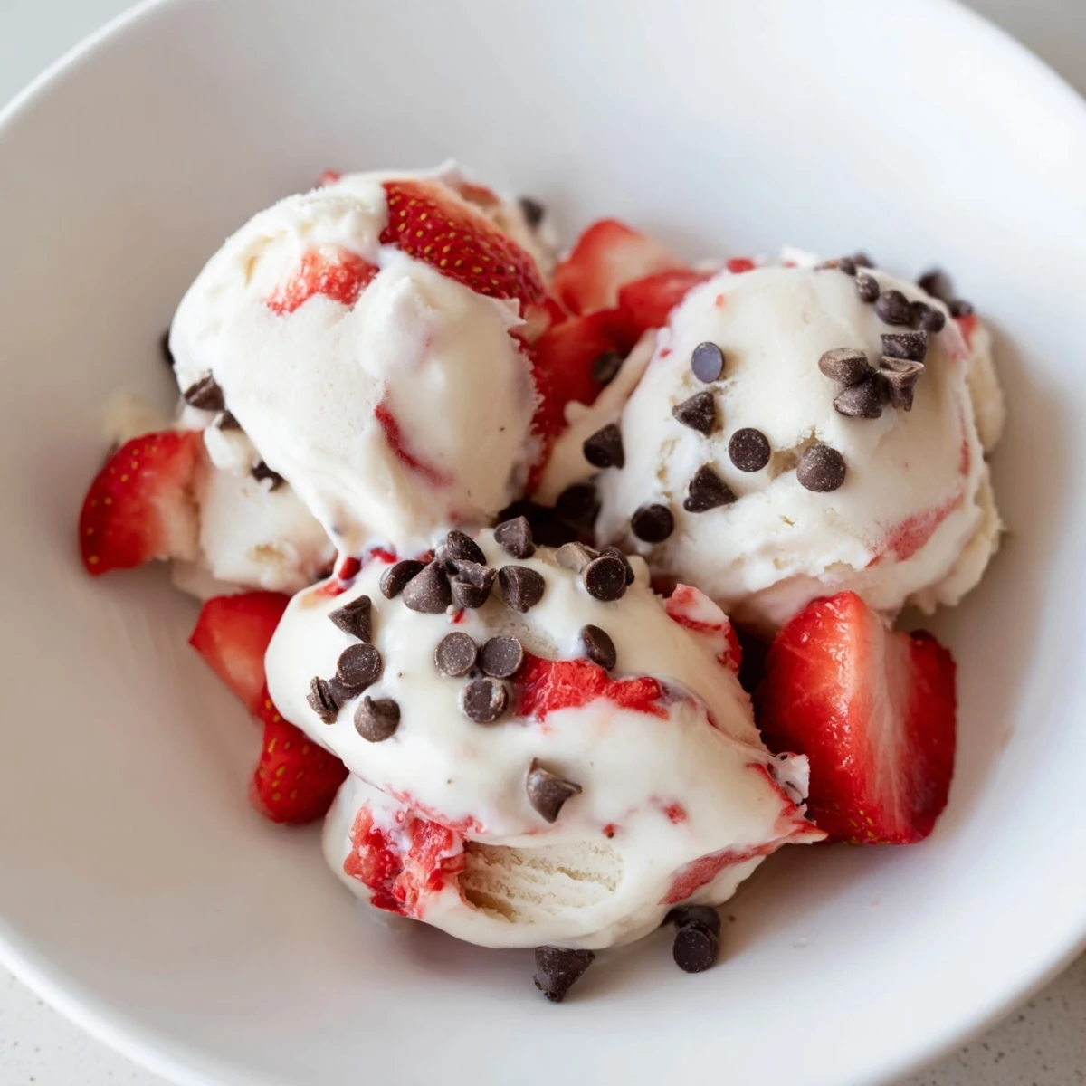 Creamy cottage cheese ice cream with fresh strawberries, ready to scoop and enjoy.