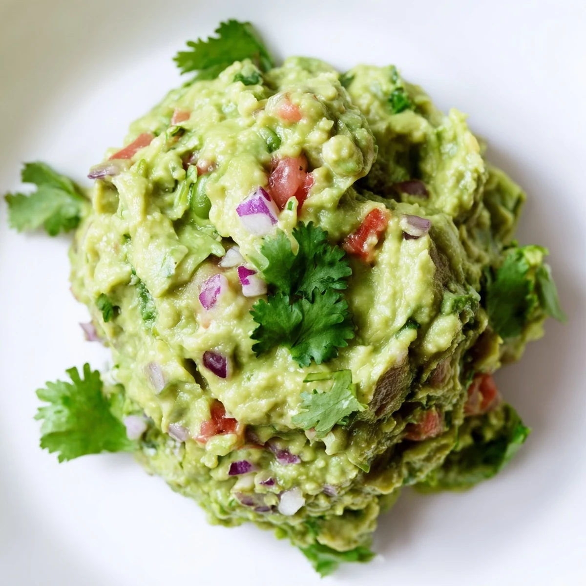 Vibrant edamame guacamole bowl with cilantro garnish, perfect for a healthy and delicious snack.