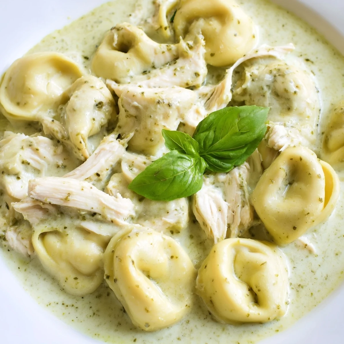Savory Creamy Pesto Tortellini Skillet served in a white bowl, paired with garlic bread and a glass of Pinot Grigio.  