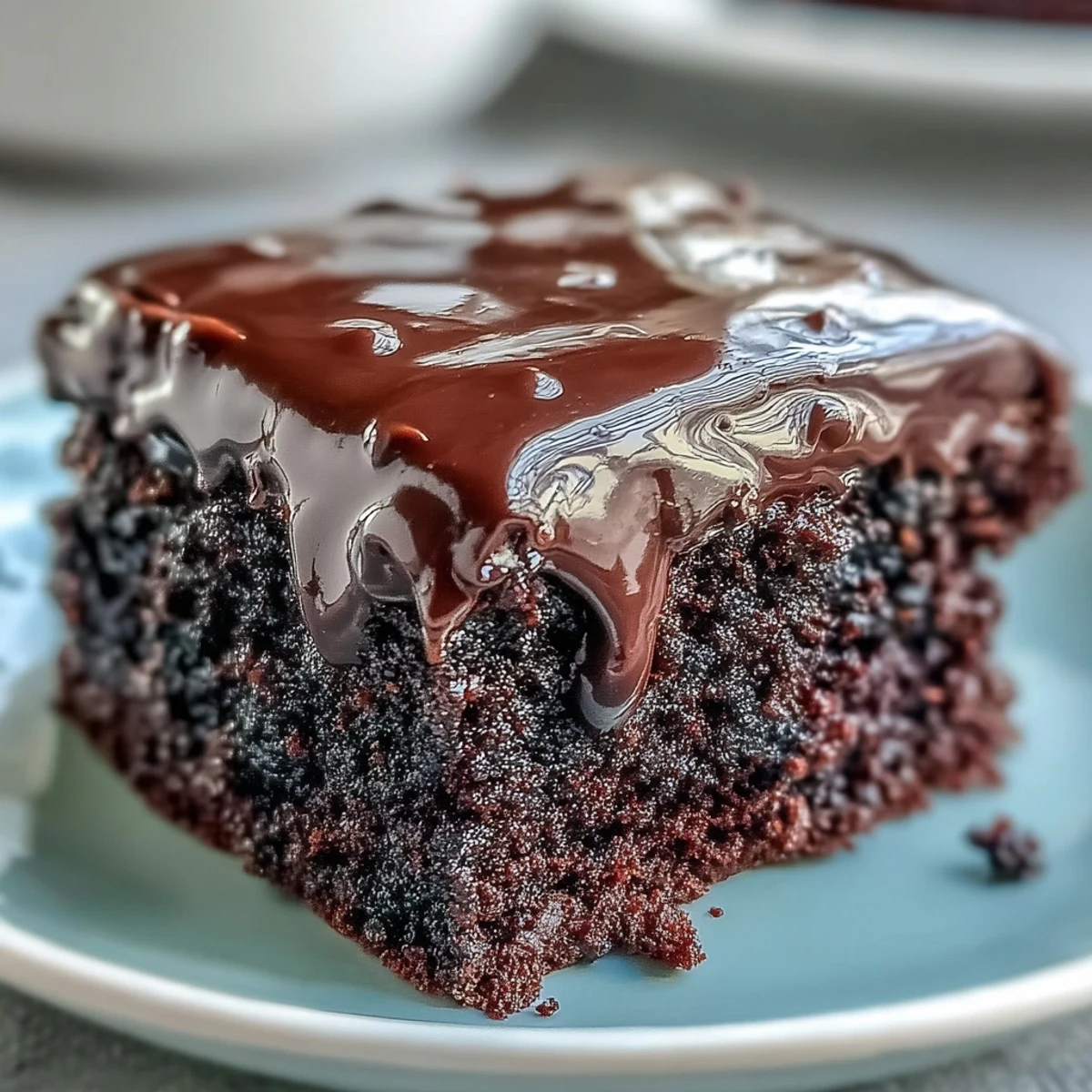 Whole Easy Chocolate Fudge Cake on a cake stand, ready to slice for an indulgent teatime treat.
