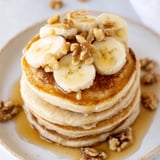 Fluffy weekend golden-brunch banana pancakes with sliced bananas and a generous drizzle of real maple syrup.