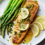 Golden, flaky Skillet Lemon-Butter Salmon served with vibrant green asparagus, ready in minutes for dinner.