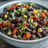 Vibrant cowboy caviar dip featuring black beans, sweet corn, and zesty pico de gallo, served chilled.  