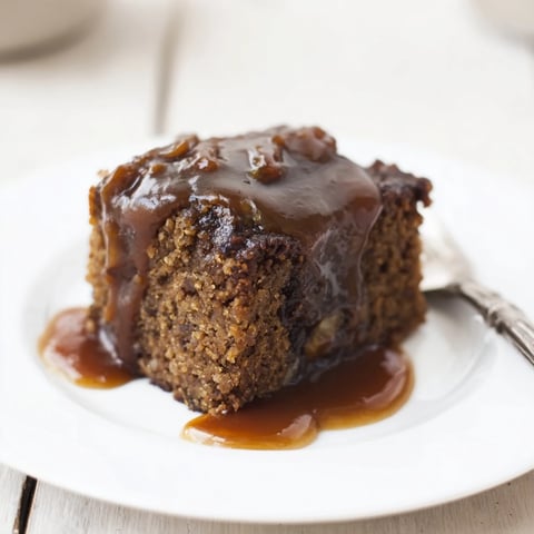 Warm Weekend Cabin-Style Sticky Toffee Pudding drizzled in glistening caramel sauce, ready to serve.