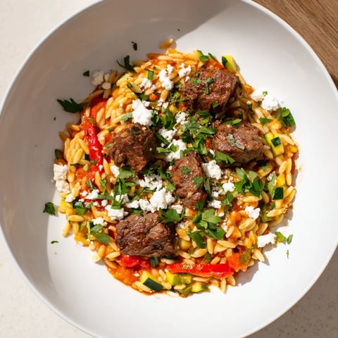 A steaming bowl of Smoky Mediterranean Lamb and Orzo Supper is ready to enjoy.