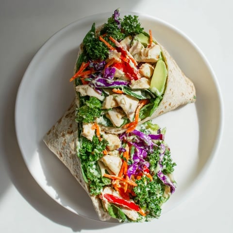 A close-up of colorful Poppy-Inspired Chicken Salad Wraps, filled with fresh vegetables.