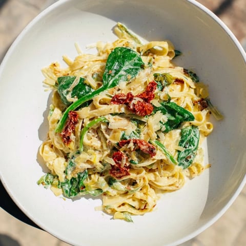 Steaming One-Pot Creamy Tuscan Garlic Herb Pasta, showcasing the vibrant spinach and sun-dried tomatoes in a creamy sauce.