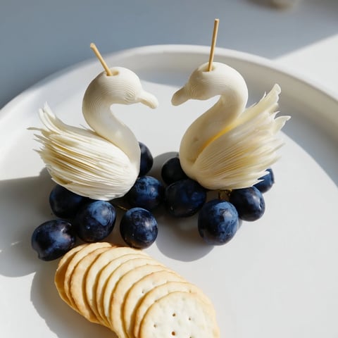 Elegant Swan Lake Board with cheese swans and vibrant blue grapes for a stunning appetizer.