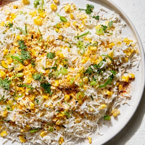 Fluffy Mexican Street Corn Rice, bursting with corn, cheese, and zesty lime, a colorful side.