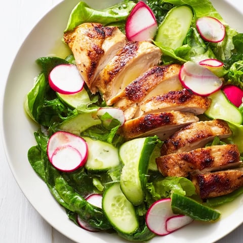Freshly grilled chicken slices rest atop mixed greens, crisp cucumber, and peppery radish in this vibrant Spring Detox Chicken Salad.  