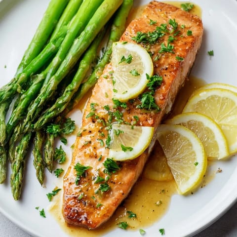 Golden, flaky Skillet Lemon-Butter Salmon served with vibrant green asparagus, ready in minutes for dinner.