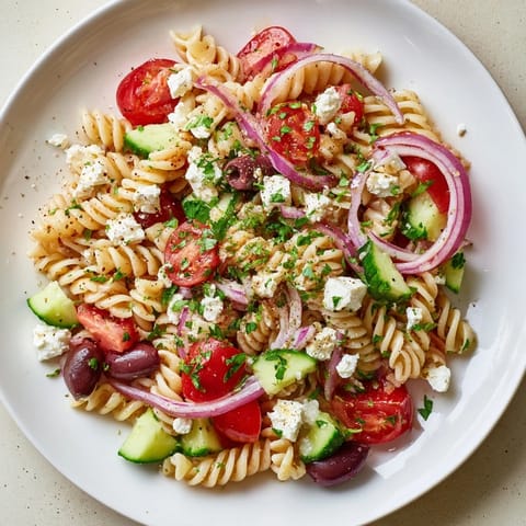 Bright picture shows a bowl of Mediterranean Olive Oil and Feta Pasta Salad, ready to be enjoyed.