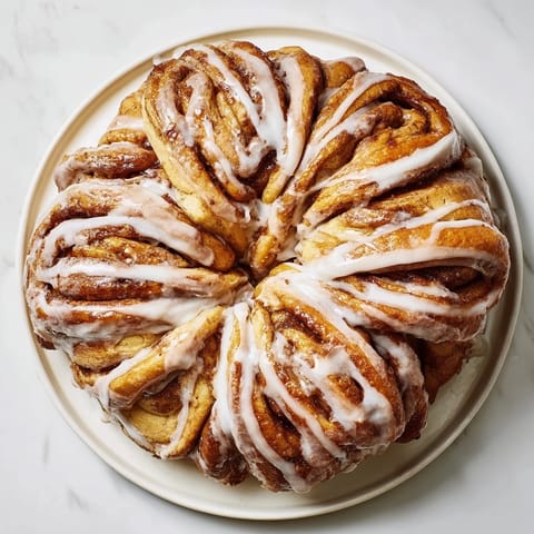 This Giant Snowflake Sweet Roll shows pulled-apart rolls, beautifully shaped, with a cinnamon-sugar filling.