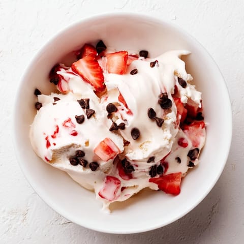 A close-up of thick, homemade cottage cheese ice cream, swirled with chocolate chips.