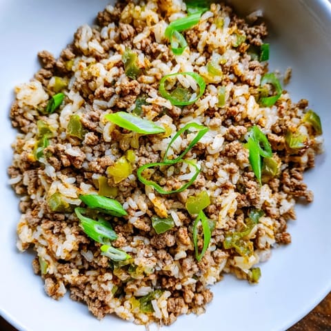 Steaming bowl of Cajun Dirty Rice, a flavorful Southern main dish, perfectly spiced with meat and vegetables.