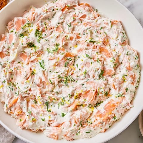 This elegant Smoked Salmon Dip features finely chopped salmon mixed into smooth cream cheese, perfect for entertaining on a wooden board.  