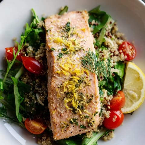 Warm salmon fillet flaked over quinoa, crisp greens, cucumber, tomatoes, and a zesty citrus vinaigrette drizzle.  