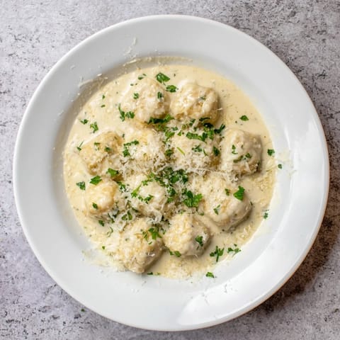 Spoonful of Creamy Garlic Chicken Bites over fluffy white rice with sautéed broccoli for a hearty meal.