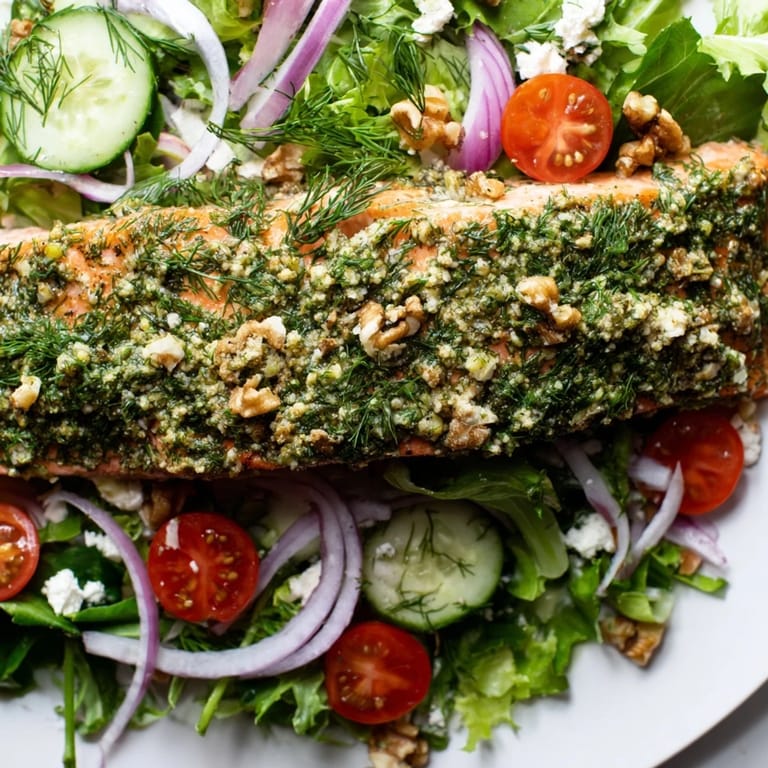 Enjoy the flavors of this refreshing herb-crusted salmon salad with bright tomatoes and cucumbers.