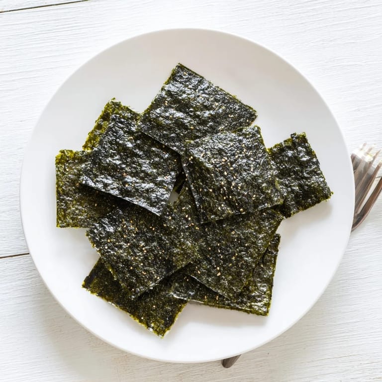 A close-up of crispy Roasted Seaweed Chips, showcasing their dark green color and crunchy, freshly roasted texture.