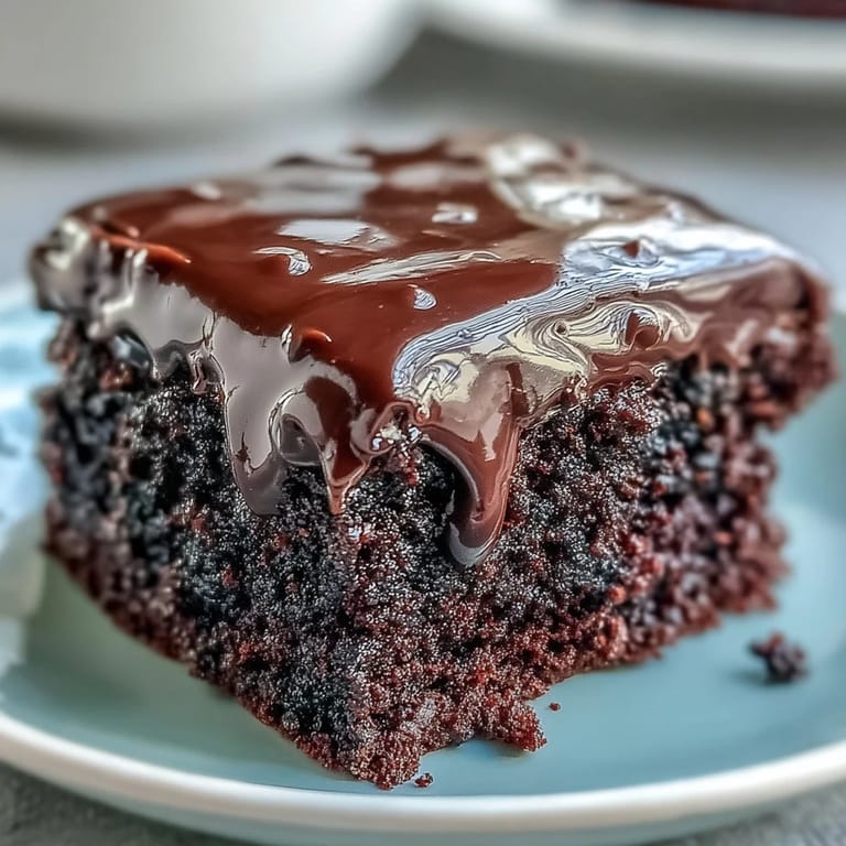 Whole Easy Chocolate Fudge Cake on a cake stand, ready to slice for an indulgent teatime treat.