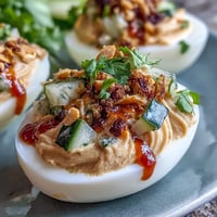Thai Peanut Deviled Eggs: creamy, spicy filling topped with fresh cucumber relish.