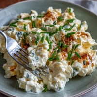 Fluffy protein-packed cottage cheese scrambled eggs studded with chives, ready to eat.